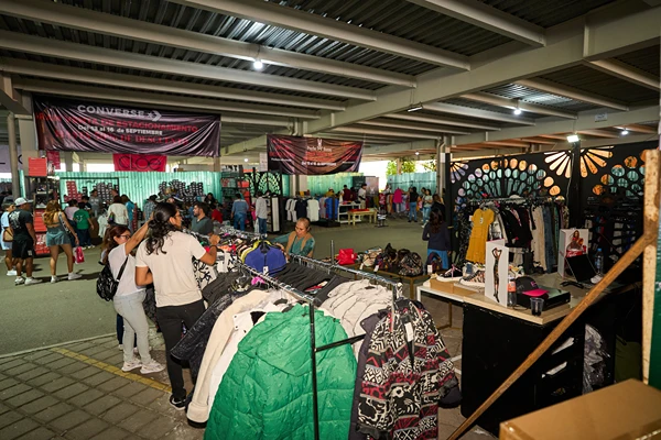 Personas comprando ropa con promociones en la Venta de Estacionamiento Outlet