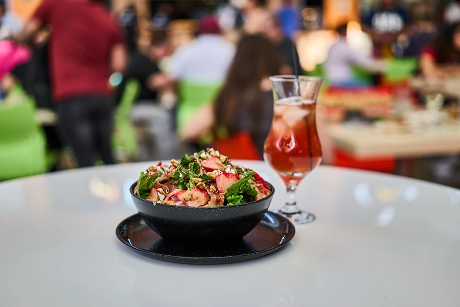 Ensalada y bebida en restaurante Trappola
