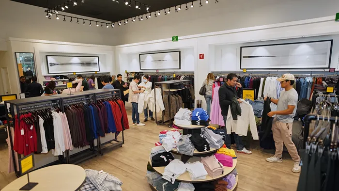 Familias comprando ropa con grandes descuentos en el pasillo de las tiendas