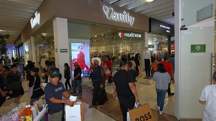 Pasillos principales de la plaza llenos de gente buscando ofertas en las mejores marcas