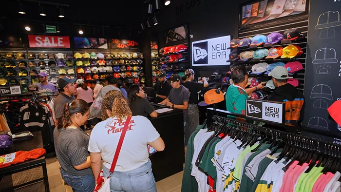 Aficionados visitando la tienda New Era para comprar gorras con descuento