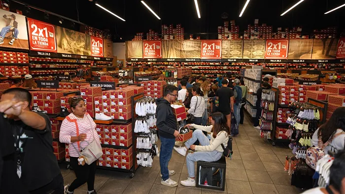Pasillo de zapaterías mostrando carteles de ofertas en calzado de marca