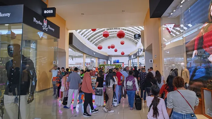 La gente disfruta del clima y las compras en la zona abierta del outlet