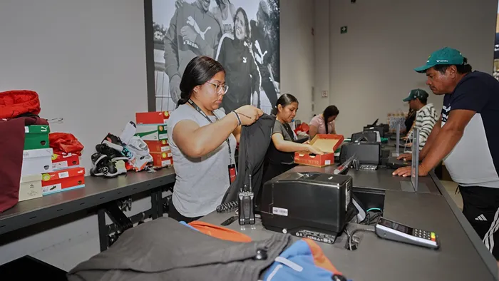 Clientes haciendo fila para pagar sus artículos Puma con descuento especial
