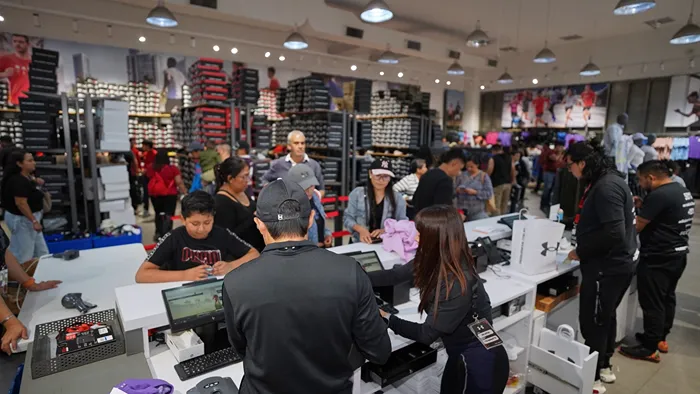 Ambiente en el interior de Under Armour con estantes llenos de ofertas