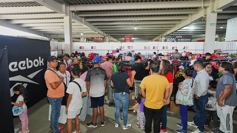 La gente compra tenis con descuentos en la Venta de Estacionamiento Outlet