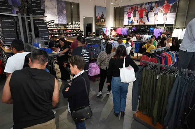 Clientes revisando outfits deportivos en la tienda Under Armour de la plaza